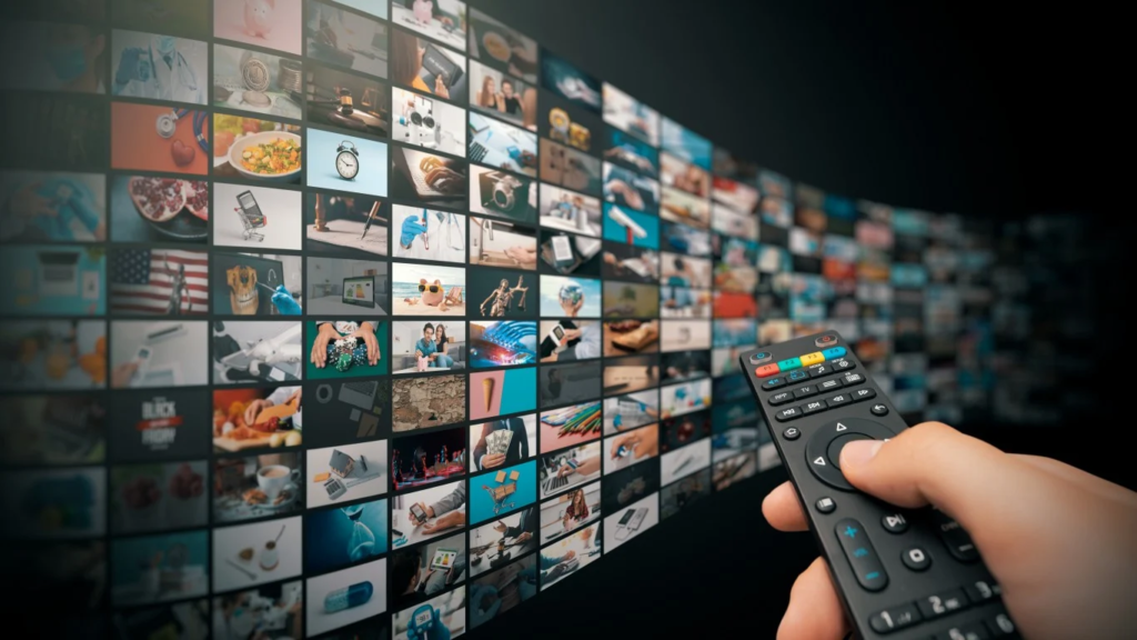 A person with a remote control in hand, facing a screen of all content that appear on tv.